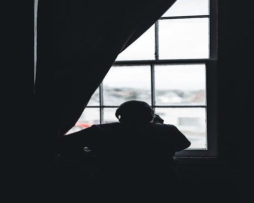 A person looking out of a window taking a break from screen