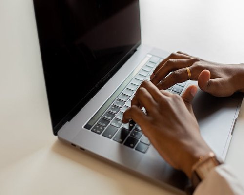 Close up of hands typing on a laptop keyboard